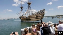 FILE - People on a wharf watch as the Mayflower II, the 1957 replica of the famed ship that carried the Pilgrims to Massachusetts in 1620, as it arrives in Plymouth Harbor in Plymouth, Mass., June 2, 2016.