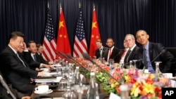 U.S. President Barack Obama, right, and China's President Xi Jingping, left, sit with members of their delegations for a meeting during the Asia-Pacific Economic Cooperation in Lima, Peru, Nov. 19, 2016. 