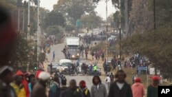 FILE: Rioters clash with Zimbabwean police in Harare, Monday, July, 4, 2016. Police in Zimbabwe's capital fired tear gas and water cannons in an attempt to quell rioting by taxi and mini bus drivers protesting what they describe as police harassment. (AP Photo/Tsvangirayi Mukwazhi)