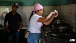 Corina Hernandez, una de las dueñas del restaurante Pancho Grill, cocina empanadas en ese local en Corozopando, Guárico, Venezuela, el 30 de mayo de 2024. El gobierno cerró su negocio luego de que vendiera comida a la dirigente opositora María Corina Machado y su equipo.