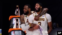 LeBron James (23) dan Anthony Davis (3) dari Los Angeles Lakers erayakan kemenangan mereka setelah Lakers mengalahkan Miami Heat 103-88 dalam Game 6 NBA Finals bola basket Minggu, 11 Oktober 2020, di Lake Buena Vista, Florida. (AP Foto / Mark J. Terrill)