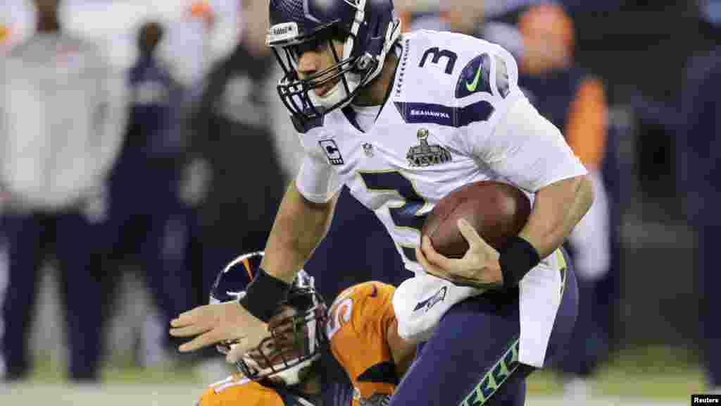 Seattle Seahawks quarterback Russell Wilson (3) breaks a tackle by Denver Broncos middle linebacker Paris Lenon during the third quarter in the NFL Super Bowl XLVIII football game.