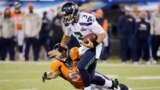 Seattle Seahawks quarterback Russell Wilson (3) breaks a tackle by Denver Broncos middle linebacker Paris Lenon during the third quarter in the NFL Super Bowl XLVIII football game in East Rutherford, New Jersey, Feb. 2, 2014.