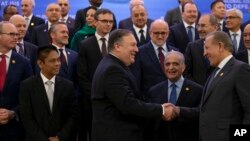 Menteri Luar Negeri Mike Pompeo (tengah) berjabat tangan dengan Menlu Kosovo Behgjet Pacolli pada pertemuan koalisi global melawan ISIS dengan 79 anggota, di Washington DC hari Rabu (6/2). 