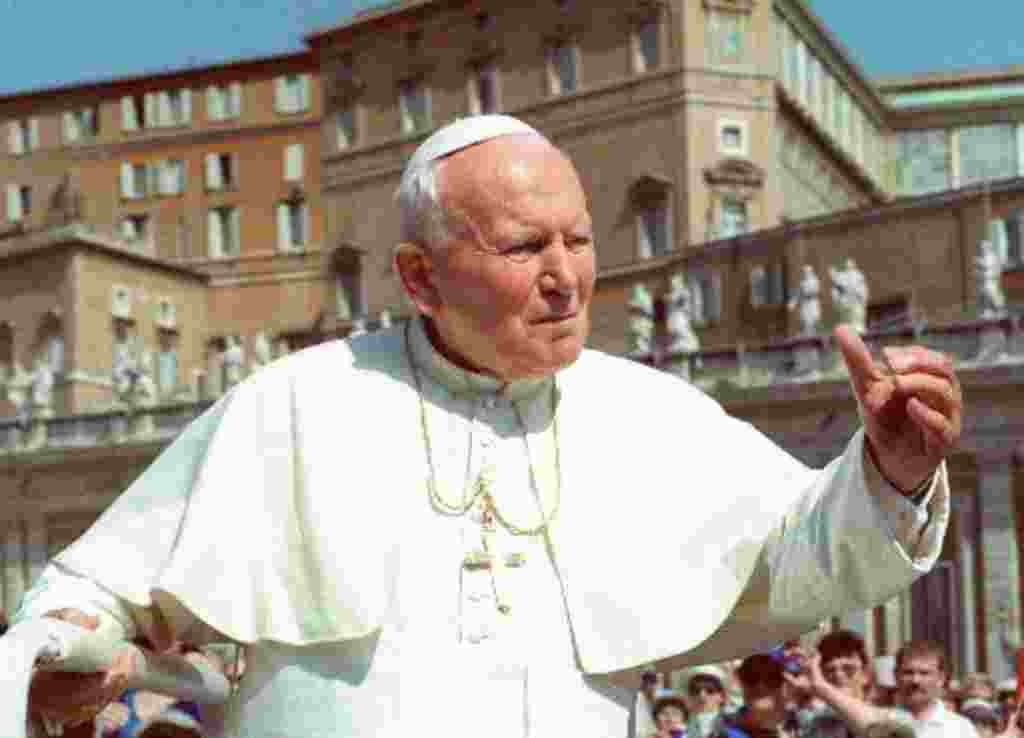 El Papa Juan Pablo II saluda a los peregrinos que llegan a la plaza de San Pedro, en el Vaticano, durante su audiencia semanal de los miércoles (1998).
