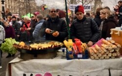 The demonstration was good for the sausage grilling business in Paris, Jan. 9, 2020. (Lisa Bryant/VOA)