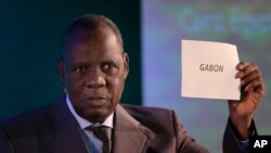 ssa Hayatou, président de la Confédération africaine de football (CAF), montre un carton indiquant le Gabon, lors du tirage au sort du pays organisateur de la CAN 2017, 8 avril 2015.