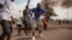 Demonstrators gather in front of a burning car during an opposition rally in Kinshasa, DRC, Sept. 19, 2016.