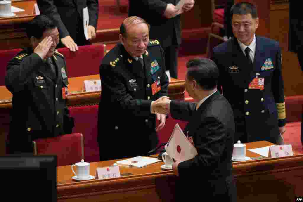 2018年3月17日，中国国家主席习近平在第十三届全国人民代表大会第一次会议结束时在北京人民大会堂与中央军委纪委书记兼中纪委副书记张升民上将握手。右侧为新的国家军委委员、海军上将苗华，敬礼者是上届国家军委委员赵克石。