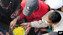 Pakistanis receive rice from a distribution facility on the roadside in Lahore on December 26, 2010.