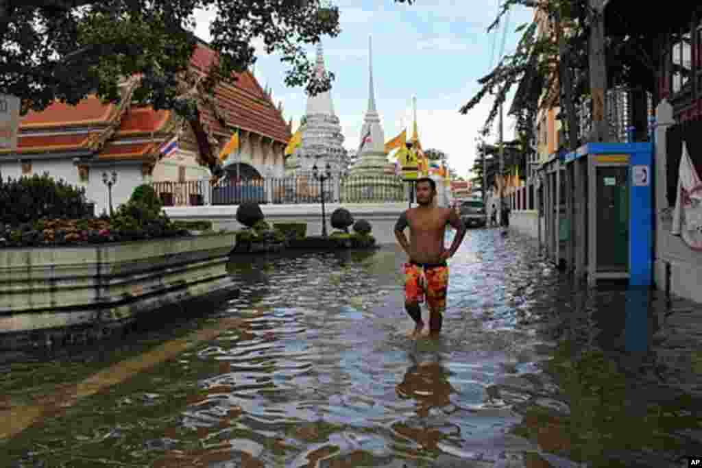 A resident from the neighborhood surrounding historical Wat Rakhang goes to pick up drinking water donations. The historical temple includes in its compound a teak house that once housed King Rama I, Bangkok, Thailand, October 28, 2011. (VOA)