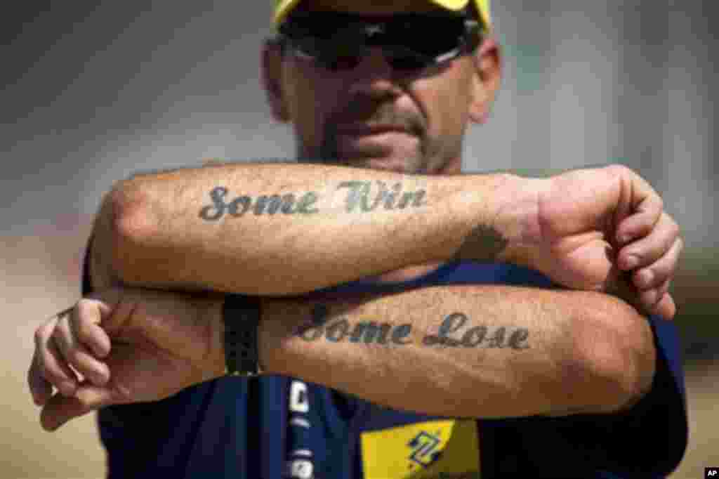 In this April 4, 2012 photo, beach volleyball trainer Abel Martinez shows his tattoos on Ipanema beach in Rio de Janeiro, Brazil. Martinez trains athletes Talita Antunes and Maria Elisa Antonelli, one of the favorite teams to compete at the London 2012 O