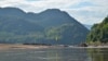 A yellow flag along the Mekong River marks the spot chosen for construction of the Luang Prabang dam near Houaygno village, Laos, Nov. 4, 2019. (Zsombor Peter/VOA)