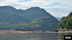 Bendera kuning di pinggiran Sungai Mekong menandai lokasi yang diilih untuk konstruksi Luang Prabang dekat Desa Houaygno, Laos, 4 November 2019. (Zsombor Peter/VOA)