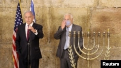 FILE - Israeli Prime Minister Benjamin Netanyahu (L) and U.S. Ambassador to Israel David M. Friedman light the first Hanukkah at the Western Wall in Jerusalem's Old City during the the Jewish holiday of Hanukkah, Dec. 10, 2020.