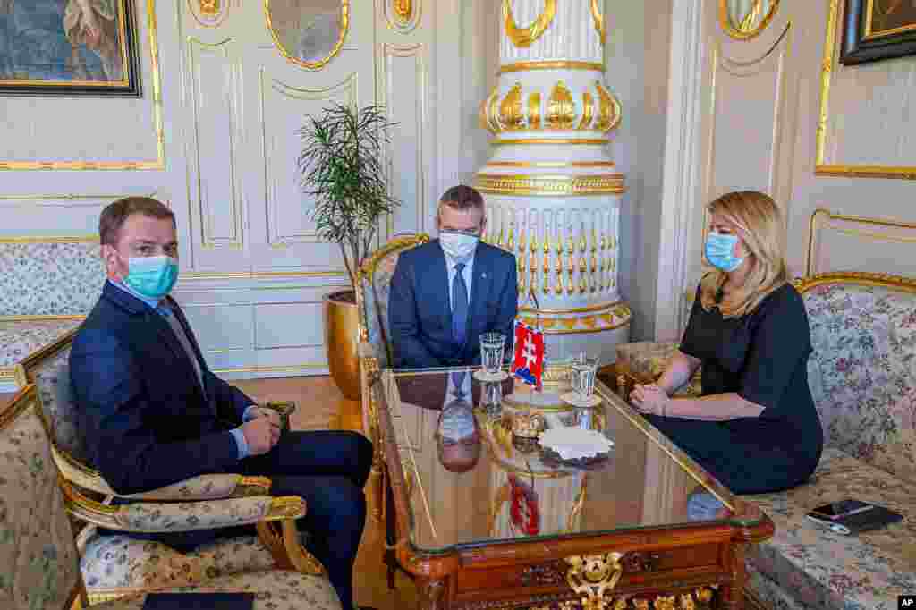 Slovakian President Zuzana Caputova, right, outgoing Prime Minister Peter Pellegrini, center, and his potential successor Igor Matovic wear face masks to protect against coronavirus, during a meeting at the Presidential Palace in Bratislava.
