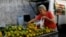 FILE - A customer selects oranges at a street market in Rio de Janeiro, Brazil, May 6, 2016. In an attempt to gain extra revenue, Brazil is poised to offer amnesty to Brazilians who return assets they hold abroad. 