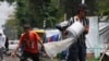 ARCHIVO - La gente drena el agua de sus tiendas de campaña después de las fuertes lluvias en un campamento de migrantes en las vías del tren de Vallejo en la Ciudad de México, el jueves 18 de julio de 2024.