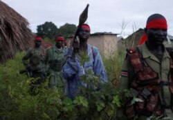 SPLA-IO rebels walk during an assault on government SPLA (Sudan People's Liberation Army) soldiers in the town of Kaya, on the border with Uganda, South Sudan, Aug. 26, 2017.