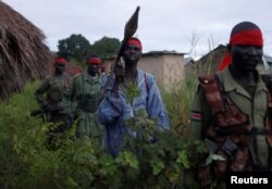 SPLA-IO rebels walk during an assault on government SPLA (Sudan People's Liberation Army) soldiers in the town of Kaya, on the border with Uganda, South Sudan, Aug. 26, 2017.