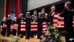 In this photo, released by the U.S. Navy, sailors fold seven U.S. flags during a memorial service in Yokosuka, south of Tokyo, Japan, June 27, 2017, for seven sailors who were killed while serving on the USS Fitzgerald when it collided with a merchant ship off Japan, June 17, 2017.