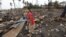 A girl walks at the site of her house, which was burned during recent violence in Sittwe, June 16, 2012. 