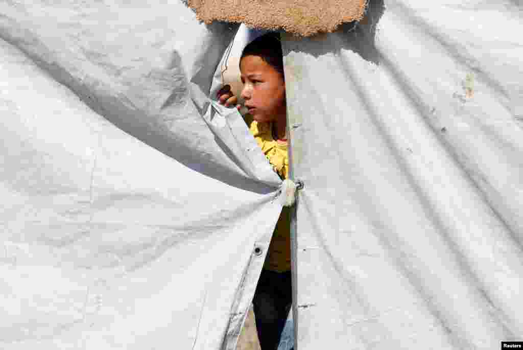 یک کودک جنگ زده و گریخته از دست داعش در یک کمپ با دوستانش بازی می کند.