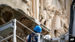 Workers inspect the 315 A.D Arch of Constantine, near the Colosseum, in Rome, Sept. 4, 2024, after lightning struck it during a storm the day before.