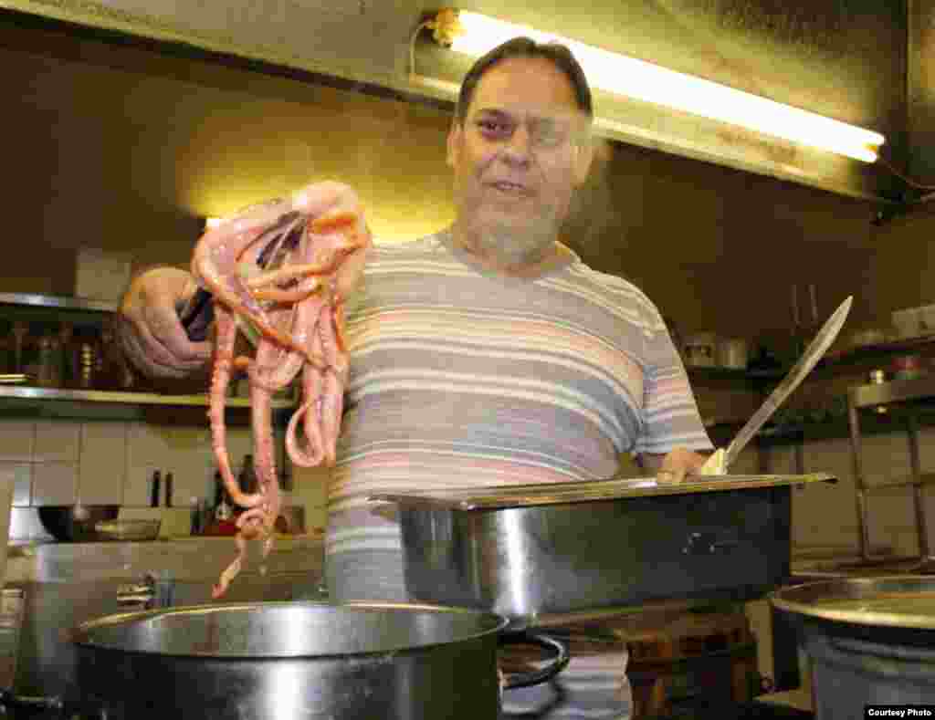 Coimbra pulls a poached octopus from the pot before grilling and serving in a rich, spicy, tomato-based sauce served with chopped potatoes listed on his Portuguese menu. Photo by Darren Taylor