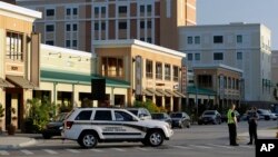 Policía de la Universidad Central de Florida bloquean una calle cerca de la torre de dormitorios donde fueron encontrados explosivos y el cuerpo de una persona que se había suicidado.