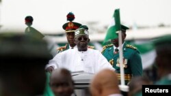 FILE - Nigeria's President Bola Tinubu looks on, as he takes the traditional ride on top of a ceremonial vehicle, after his swearing-in ceremony in Abuja, Nigeria May 29, 2023. 