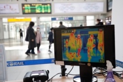 A thermal camera monitor shows the body temperature of people at the Seoul Railway Station in Seoul, South Korea, March 2, 2020.