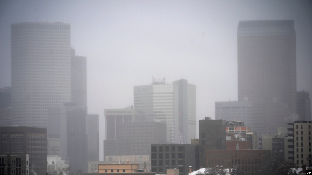 A light snow shrouds the skyline as a winter storm sweeps over the intermountain West, Jan. 18, 2025, in Denver.