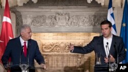 Greek Prime Minister Alexis Tsipras, right, answers a question during a press conference with his Turkish counterpart Binali Yildirim after their meeting in Athens, June 19, 2017.