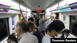 Iranians wearing protective face masks ride the metro, following the outbreak of the coronavirus disease (COVID-19), in Tehran