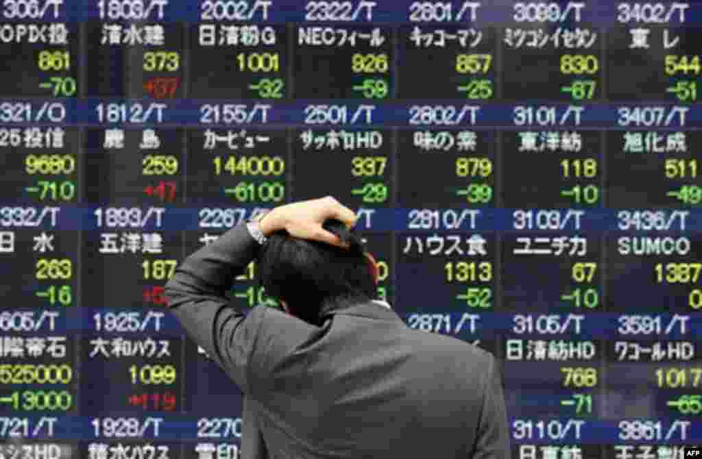 A man reacts while looking at a stock price board in Tokyo Monday, March 14, 2011 as the Tokyo stock market plunged on its first business day after an earthquake and tsunami of epic proportions laid waste to cities along Japan's northeast coast. Only stoc