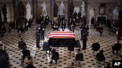 A U.S. Capitol Police honor guard surrounds the flag-draped casket of Justice Ruth Bader Ginsburg as lies in state in Statuary Hall of the U.S. Capitol, Sept. 25, 2020 in Washington.