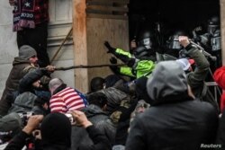 Los partidarios del presidente de los Estados Unidos, Donald Trump, se enfrentan a la policía en la entrada oeste del Capitolio durante una protesta "Stop the Steal" frente al edificio del Capitolio en Washington DC, el 6 de enero de 2021.