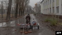 Un residente local llena botellas con agua en Pokrovsk, en la región oriental de Donetsk, el 11 de diciembre de 2024, en medio de la invasión rusa de Ucrania. (Foto de Roman PILIPEY / AFP)