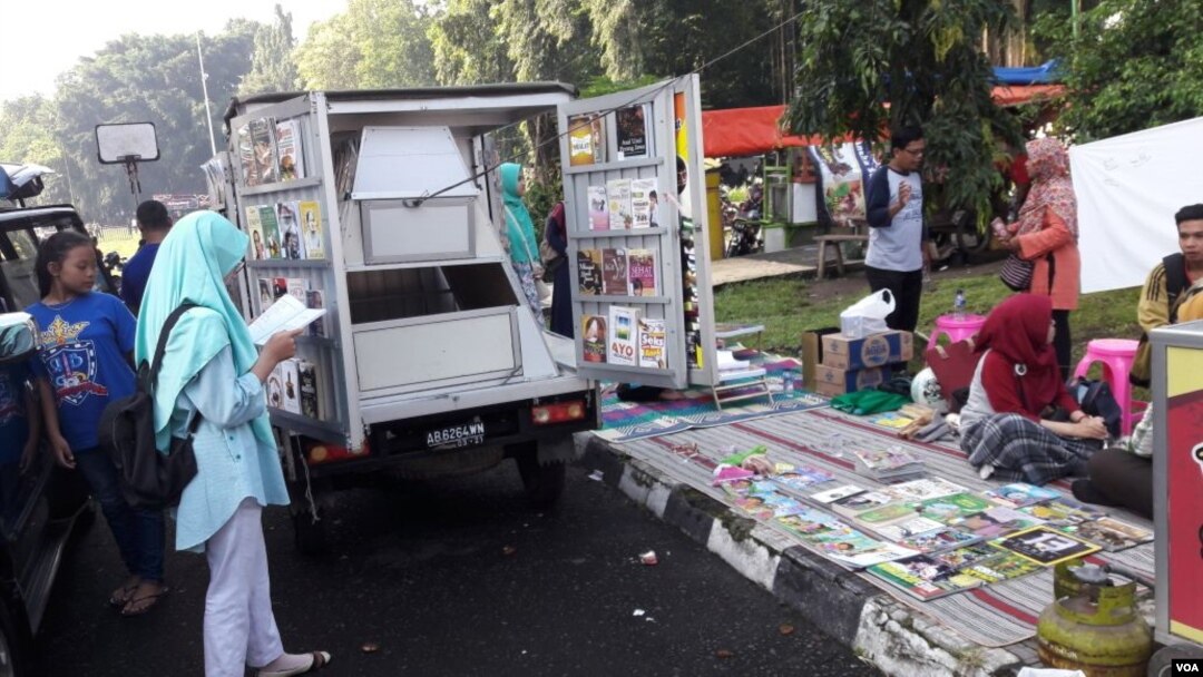 Anak-anak berkerumun di perpustakaan keliling yang dikelola Rakhmadi Gunawan di Yogyakarta. (VOA/Nurhadi)
