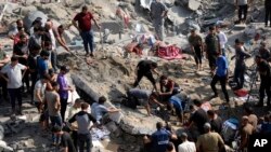 FILE - Palestinians work among debris of buildings that were targeted by Israeli airstrikes in Jabaliya refugee camp, northern Gaza Strip on November 1, 2023.