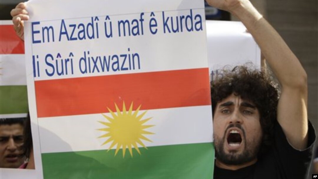 Seorang Kurdi dalam sebuah protes anti Presiden Suriah Assad di depan Kedubes Suriah di Lebanon (23/10/2011). Spanduk yang dibawanya berbunyi "Kami ingin kebebasan dan hak untuk orang Kurdi di Suriah".