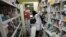 FILE - An Iranian pharmacist arranges medicine on shelves at a pharmacy in central Tehran, Iran, Dec. 11, 2012. The strength of the U.S. dollar and concerns that the U.S. will again impose tough economic sanctions have prompted the price of pharmaceuticals to jump.
