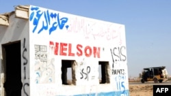 Sebuah pos pemeriksaan polisi di pinggiran Kota Karachi yang tidak dipakai tampak dicoret-coret dengan grafiti bertuliskan “ISIS” di Karachi, Pakistan, 16 Oktober 2014. (Foto: Asif Hassan/AFP)
