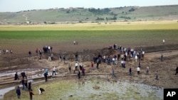 Warga setempat mengamati kerusakan di lokasi terjadinya ledakan di Sarikamis, Diyarbakir, Turki (13/5). 