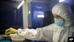 A staffer works with test systems for the diagnosis of coronavirus at the Krasnodar Center for Hygiene and Epidemiology lab in Krasnodar, Russia, Feb. 4, 2020. Russia has shut its land border with China and suspended most train traffic between them.