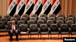 FILE - Iraqi Prime Minister Haider al-Abadi sits during a parliamentary session to vote on Iraq's new government at the parliament headquarters in Baghdad, Sep. 8, 2014.