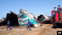 Members of Burma's Fire Brigade team gather near a damaged Air Bagan passenger plane in Heho, Shan State, Dec. 25, 2012.