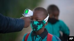 지난달 7일 남아프리카공화국 요하네스버그의 학교에서 등교하는 학생들의 체온을 재고 있다.