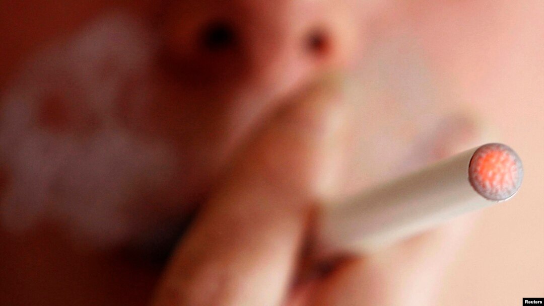 A woman smokes an e-cigarette, an electronic substitute in the form of a rod, slightly longer than a normal cigarette, in Bordeaux, southwestern France, in this file photo.